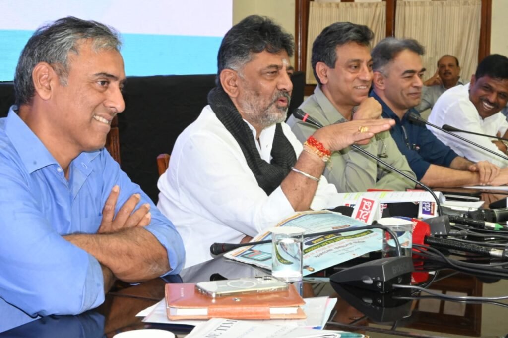 The image features the team responsible for implementing the E-Khata project, led by Deputy Chief Minister DK Shivakumar. From left to right, the first individual is GBA Chief Commissioner M Maheshwar Rao. The third person is Additional Chief Secretary (UDD) Tushar Giri Nath, followed by GBA (Revenue) Special Commissioner Munish Moudgil.